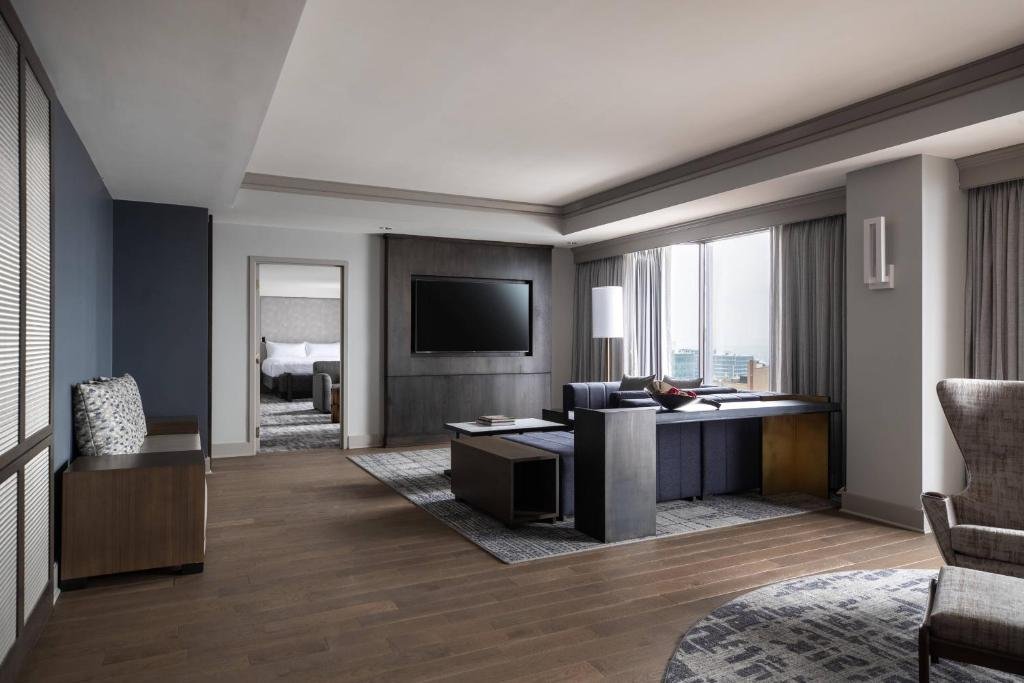 Modern hotel room with bed, sofa, and flat-screen TV