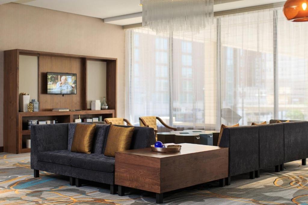 Large, well-lit hotel suite with modern couch and tall windows